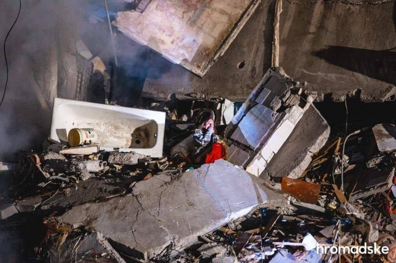 一名年輕女子絕望坐在遭俄羅斯飛彈擊毀的自家公寓，雖然幸運生還，不過父母仍在瓦礫堆下，生死未卜。   圖：翻攝自@DefenceU Twitter
