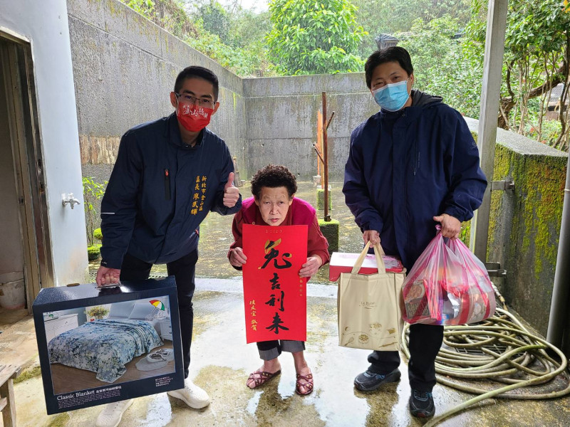 廖武輝致贈公所保暖物資給獨居長輩曾老太太。   圖：金山區公所提供