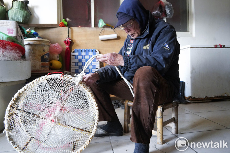 冬天風浪大無法出海，住在福正村的曹木花老先生在家裡修補章魚籠。   圖：張良一/攝