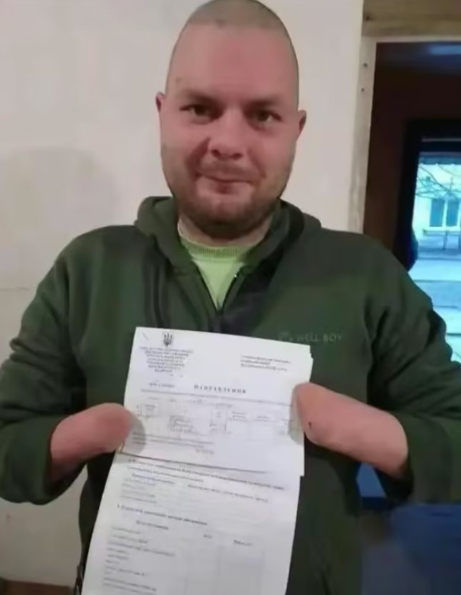 一名雙手截肢的烏克蘭人展示他收到的徵兵令。   圖 : 翻攝自騰訊新聞