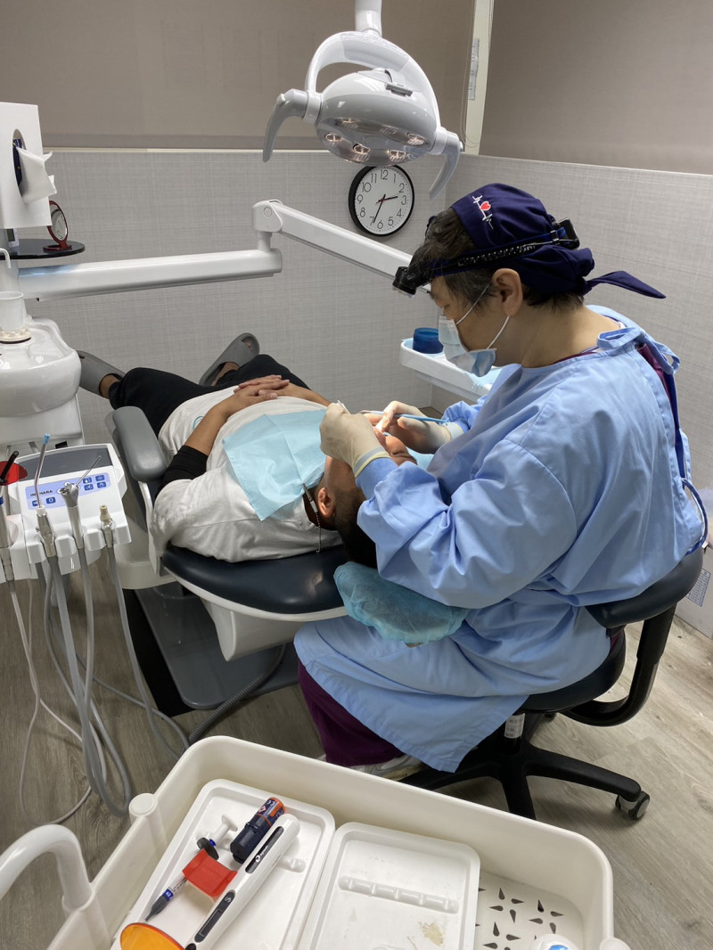 烏來區口腔醫療站牙醫師為族人評估裝置假牙情形。   圖：新北市政府原民局提供