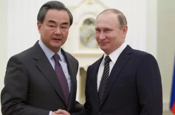 俄羅斯總統普丁（右）22日在克里姆林宮接見到訪的中共最高層級外交官王毅（左）。   圖：翻攝俄羅斯衛星通訊社