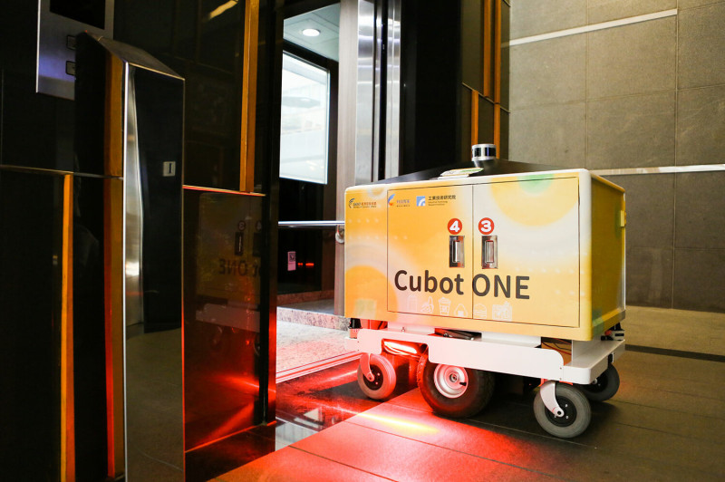 工研院機器人外送員Cubot ONE透過5G連網整合技術，能自主與電梯溝通、進出電梯，完成跨樓層送餐。   圖：取自經濟部技術處補助工研院官網