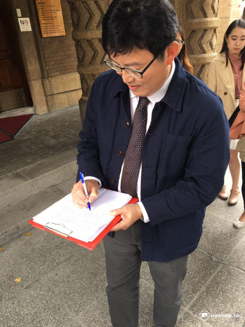 姚文智正在簽署廢除《國立中正紀念堂管理處組織法》連署書。   圖：鍾孟軒/攝