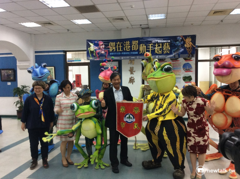 林永發將「榮譽市民」獎旗，給無獨有偶劇團的蛙蛙們   圖：程士華/攝