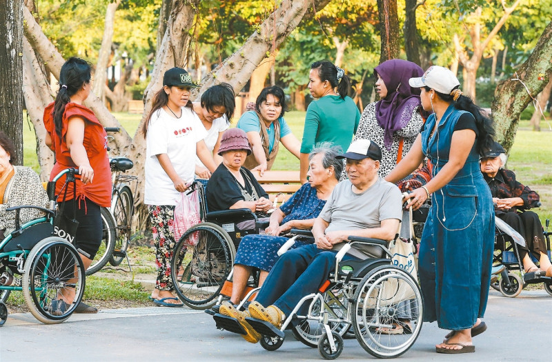 外籍勞工在公園看護老年民眾。   圖:翻攝自網路。