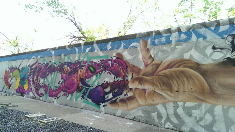 塗鴨藝術家「逃亡計劃街頭藝術團隊」，在牆上創作長度約100公尺的大型環保塗鴉，原本雜亂的牆面，在藝術家們的巧思下，變身成為充滿美感的藝術作品。   圖：台中市政府提供