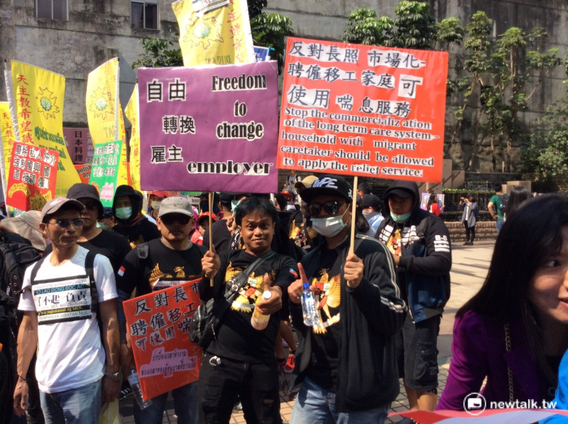 移工們用母語及中文寫下「自由轉換雇主」、「反對長照市場化」「聘雇移工家庭可使用喘息服務」等訴求。   圖：程士華/攝
