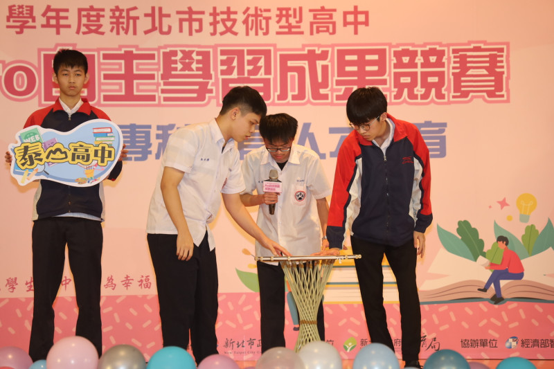 泰山高中機械科學生林伯懌（左2）、朱庭鈞（右2）、陳煜喆（右1）介紹莫比烏斯桌。   圖：新北市教育局提供