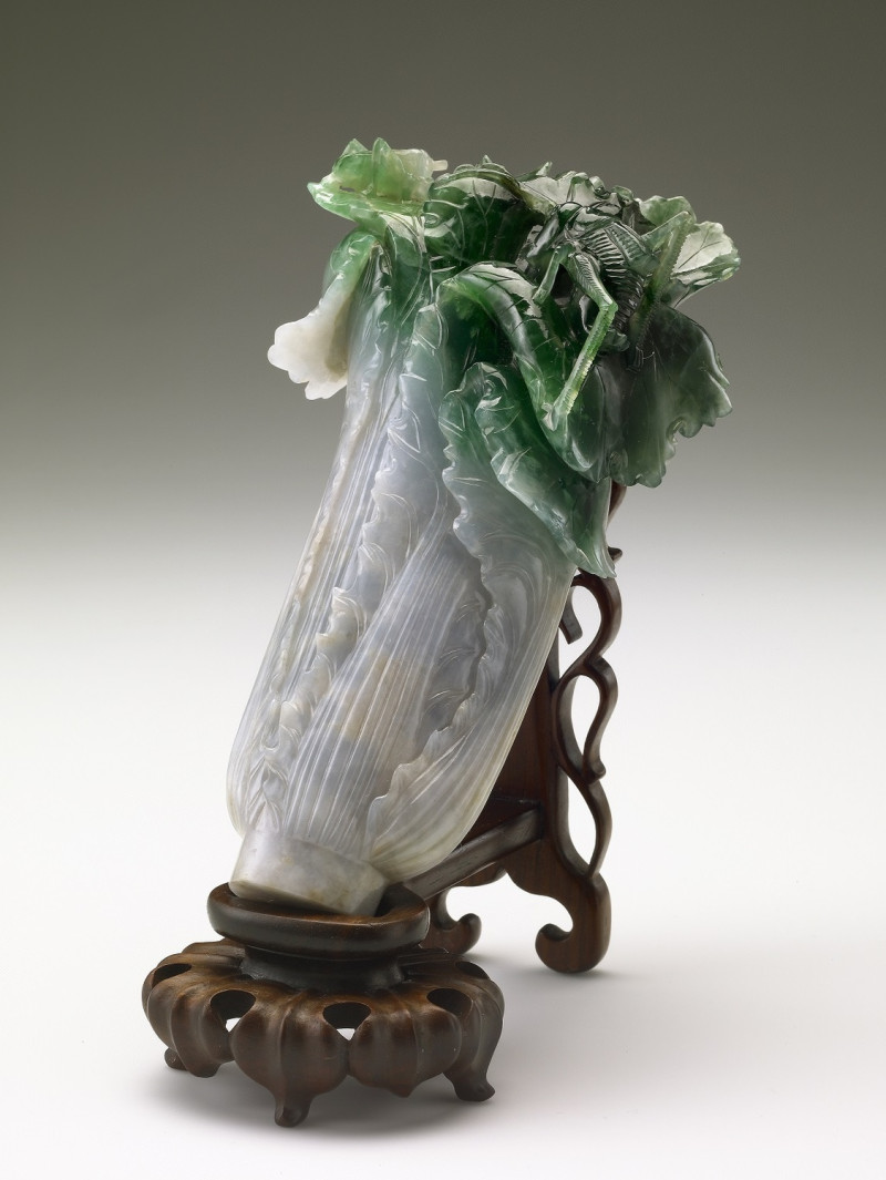 國寶「翠玉白菜」是以一塊同時具有濃綠、斑白的翡翠為材料雕刻而成，菜葉頂端還刻上螽蟴與蝗蟲，栩栩如生。   圖：翻攝自故宮官網