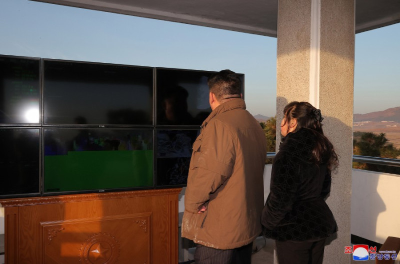 北韓16日進行「火星-17」洲際彈道導彈發射訓練。金正恩愛女金朱愛同行(背影照片右側)。   圖：翻攝朝中社