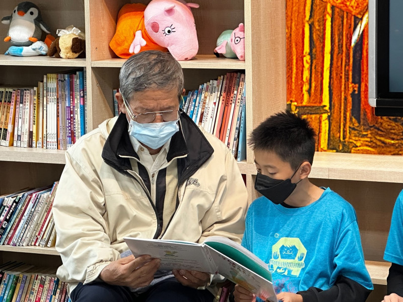 十分國小蘇禎松爺爺（左）和學生周晏瑋（右）共讀《跨代的對話：請聽我說》。   圖：新北市教育局提供