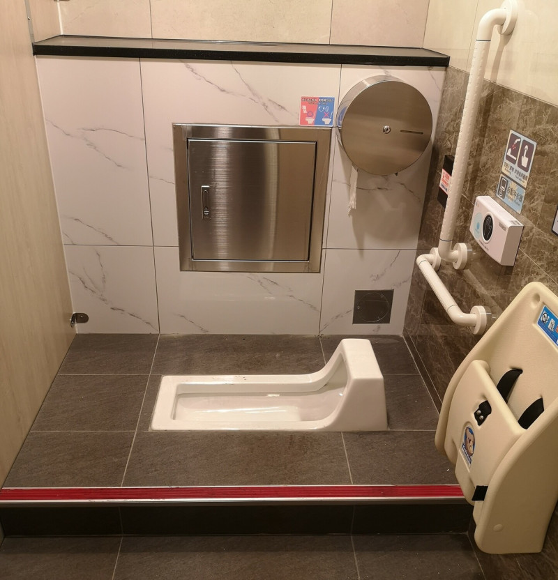 捷運海山站男廁蹲式廁間內設有嬰兒坐椅。   圖：新北市捷運局提供
