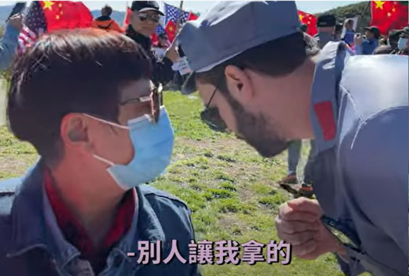 一名拿著收音機播放抗議話語的中國走路工告訴樂樂法利「別人要我拿的」。   圖：翻攝樂樂法利YouTube影片