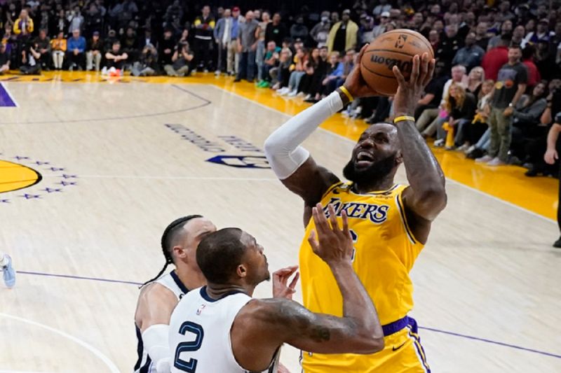 LeBron James面對灰熊防守者完成高難度上籃，最終幫助球隊在延長賽贏球。   圖／美聯社／達志影像