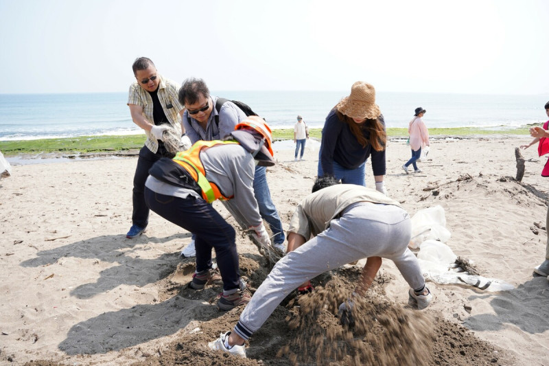 民眾與清潔隊員合力淨灘。   圖：新北市環保局提供