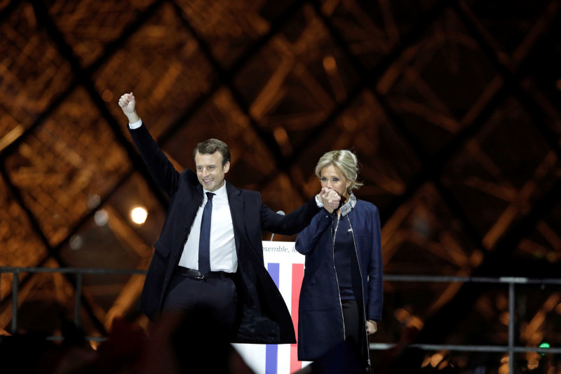 新科法國總統馬克宏（左）牽著大他24歲的妻子碧姬‧托涅的手，共同分享勝選喜悅。   圖：達志影像/路透社