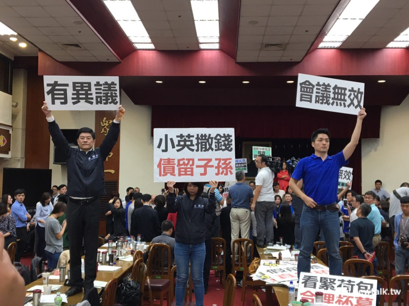 國民黨立委站在桌上手舉標語表示抗議。   圖：鍾孟軒/攝