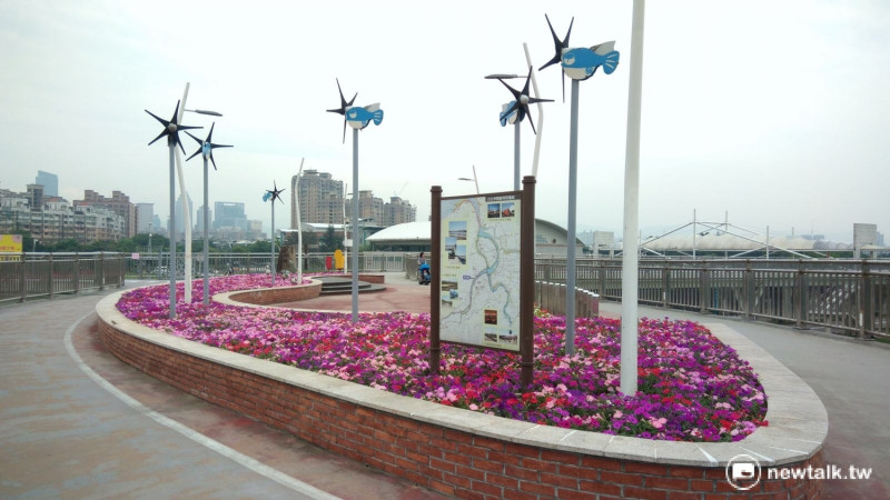 新月橋「風之律」觀景平台上，設置多支不同角度的小魚造型風車。   圖：新北市提供