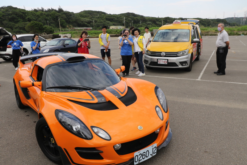 小樂坐上蓮花跑車兜風現場志工開心的錄影。   圖：新北市社會局提供