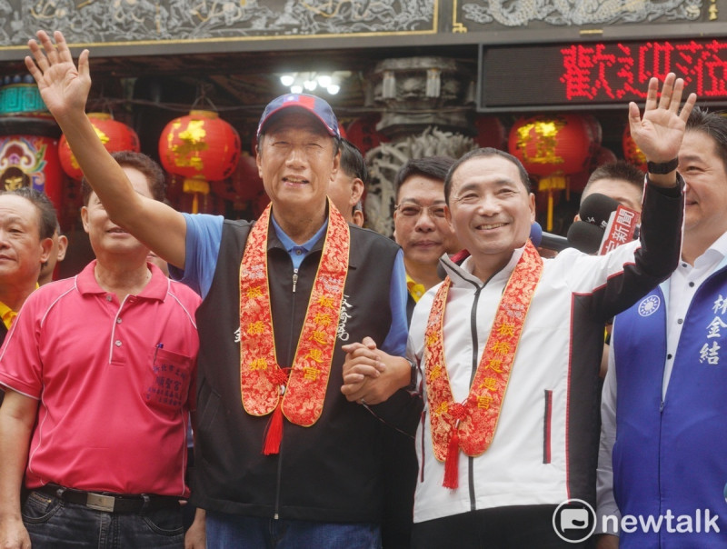 板橋慈惠宮媽祖聖誕並舉行遶境祈福活動，國民黨內兩大總統候選人熱門人物-郭台銘與侯友宜合體向媽祖祝禱並一起點燃起馬炮，兩人隨後一起向媒體揮手致意。   圖：張良一/攝