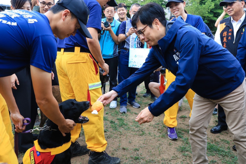 陳其邁(右)與救援犬互動。   圖：高雄市消防局/提供