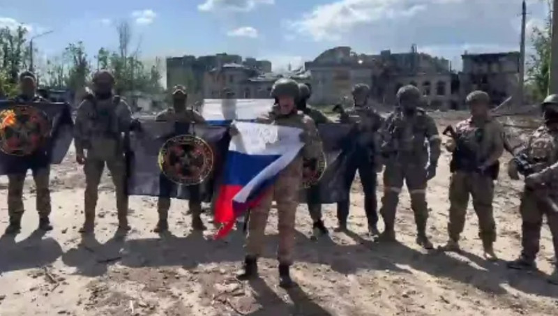 普里戈津拿著俄國國旗，與瓦格納軍團士兵合影。   圖：翻攝自推特