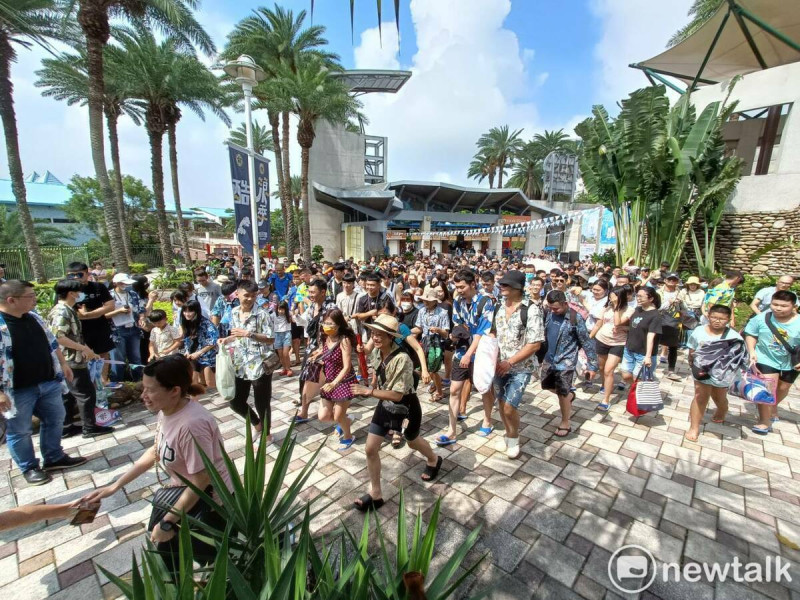 眾多遊客穿著藍白拖、花襯衫享受199入園大優惠。   圖：唐復年/攝
