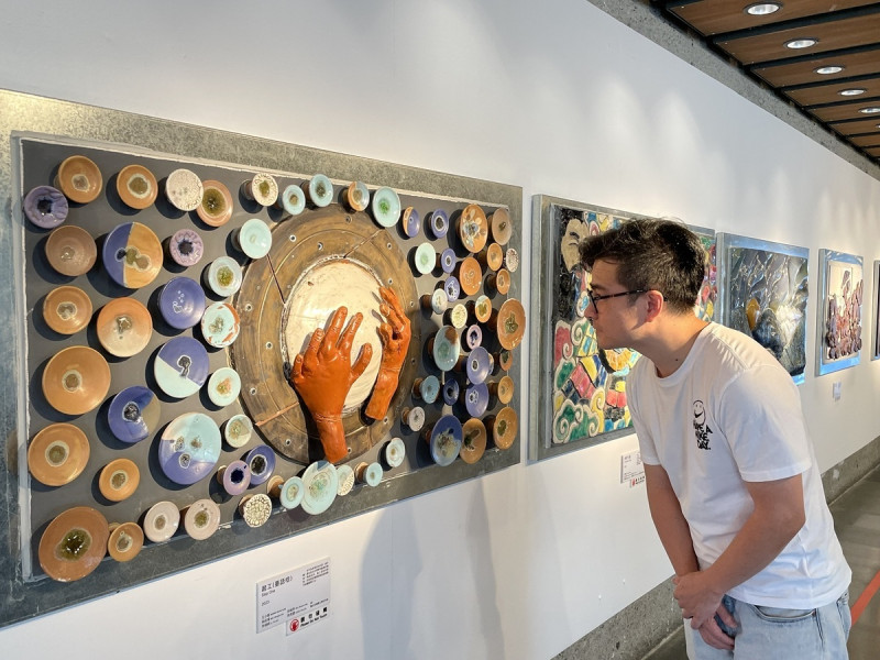 《起工》一雙具溫度的雙手，搭配拉坯成形的67個釉色雅樸的圓盤，期許不忘做陶初衷。   圖：鶯歌陶瓷博物館提供