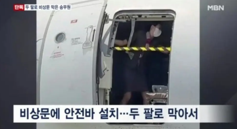 南韓國內線一架客機26日在航行時，艙門被乘客蓄意打開，空姐用身體擋住艙門，疑似是航班降落後的場景。   圖: 擷取自南韓 MBN 電視台畫面