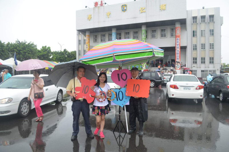 國民黨黨代表候選人林雪峰（中）在風雨中積極拉票。   圖：蔡坤龍/攝
