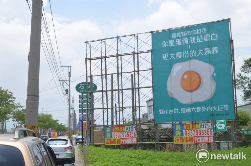 面立於嘉義市北港路的「蛋黃蛋白」廣告看板，23日同時引發縣市議會質詢。   圖：蔡坤龍/攝