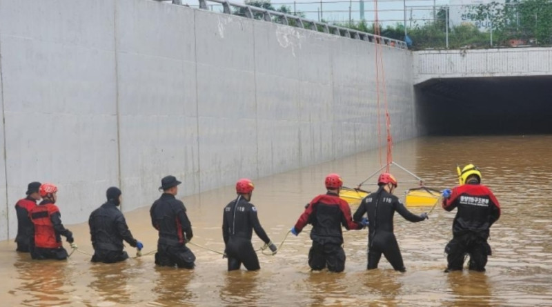 韓國救援人員沿著一條被洪水淹沒的道路搜尋失蹤人員，這條道路通往被洪水淹沒的地下隧道。   圖：翻攝自中新網