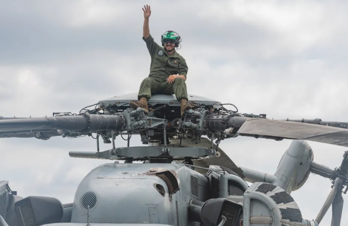 美軍陸戰隊機組員坐在CH-53直升機槳轂上，向參觀民眾揮手致意。   圖 : 翻攝自DVIDS網站
