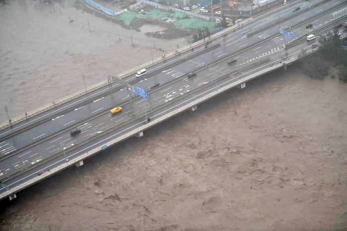 北京永定河水位暴漲，幾乎快淹過沿岸橋梁。   圖：翻攝自北京青年報微博