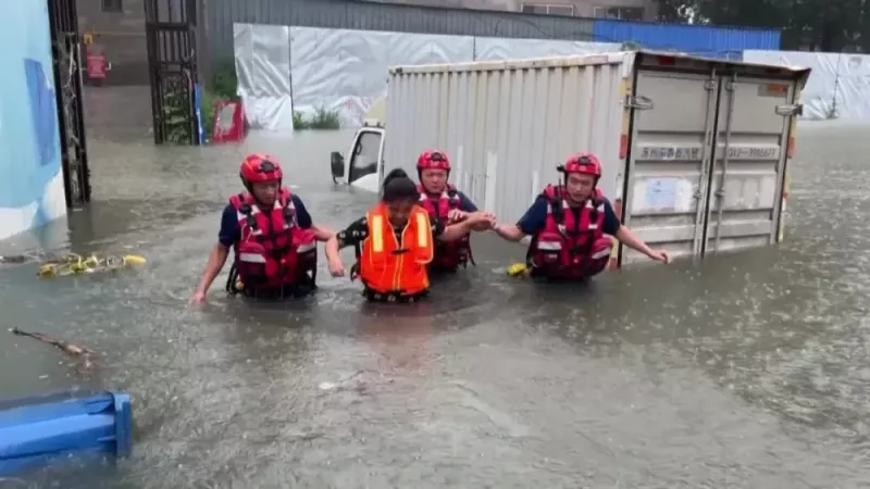 北京暴雨，河北省涿州面臨嚴重洪災，搜救隊員救出一名受困卡車的婦女。   圖：翻攝自騰訊網／《南方人物周刊》