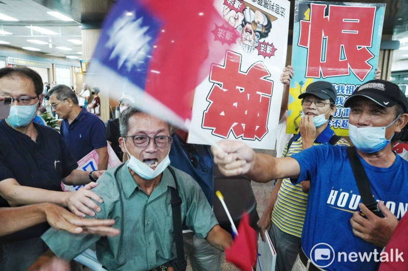 新北市民欲攔路陳情，而侯友宜的支持者則用國旗擋住陳情民眾的視線。   圖：張良一/攝