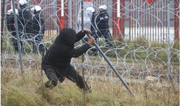 一個非法移民企圖穿越波蘭邊境的鐵絲網。 圖 : 翻攝自騰訊網/湘評中外