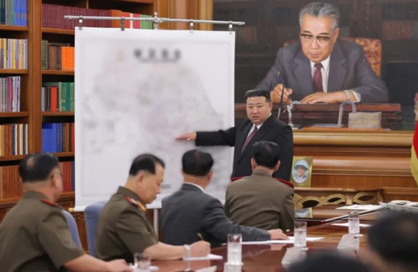 金正恩拿出有韓國地圖的圖表，指示將領們要積極備戰。   圖：翻攝自朝中社