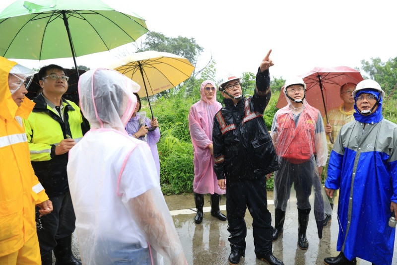 陳其邁(中)冒雨視察寶來一號橋邊邊坡崩塌情形。   圖：高雄市水利局提供