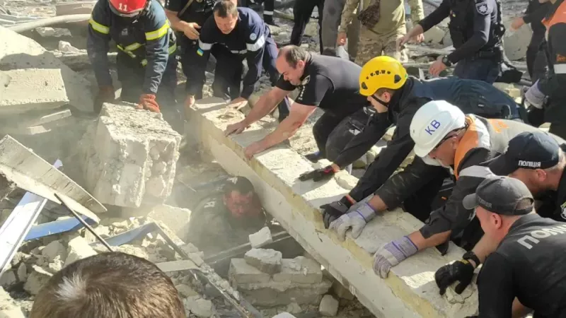 有受傷的軍人被壓在建築物的殘骸中，營救人員合力把建築物殘骸搬起。   圖：翻攝自勝研集