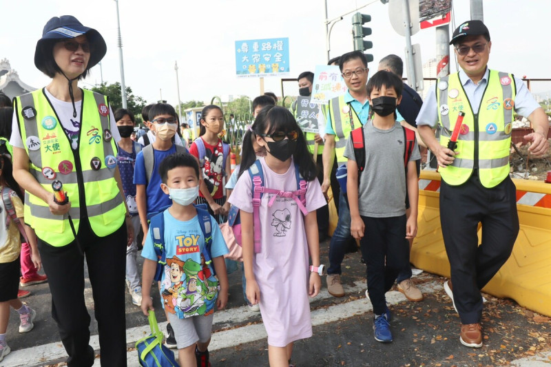 謝文斌(右一)、張淑娟(左一)陪小學生過馬路。   圖：高雄市教育局提供