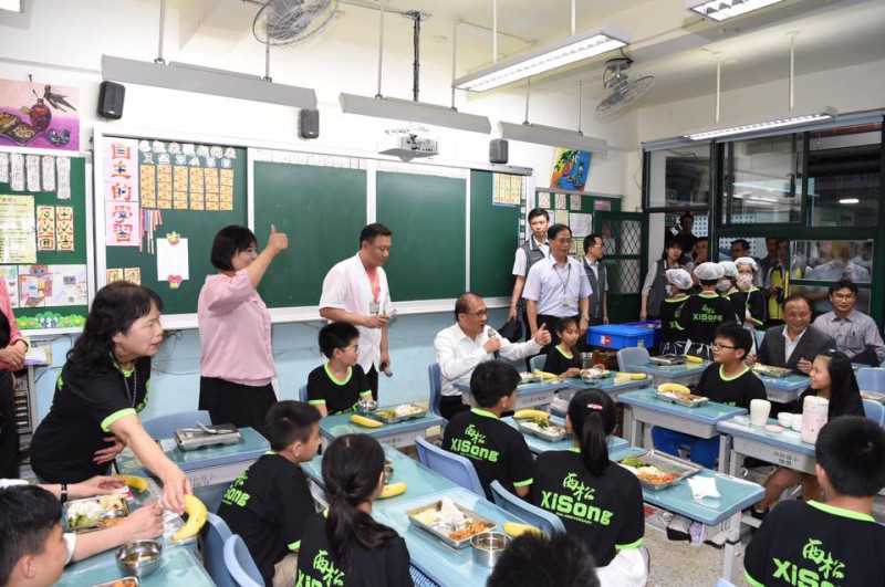 行政院長林全２日前往台北市西松國小瞭解「四章一Q」的辦理情形，並開心的與該校5年1班的學童共享營養午餐。   圖：行政院提供