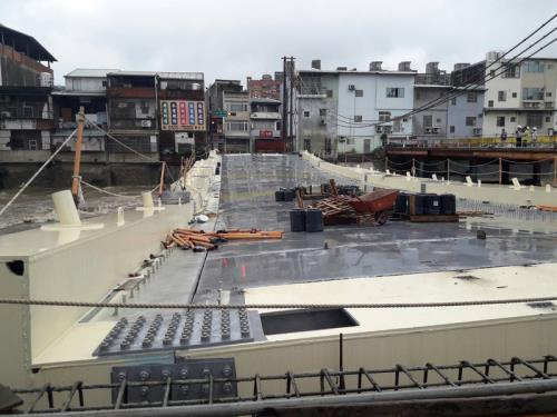 桃園市南崁溪南通橋臨時支撐架因暴雨被滾滾洪水沖走，橋面塌陷，桃園市桃園區公所表示，河道中央臨時支撐流失一處，另一處下陷，但並無裂縫或位移，工程品質無礙。   圖：桃園市消防局提供