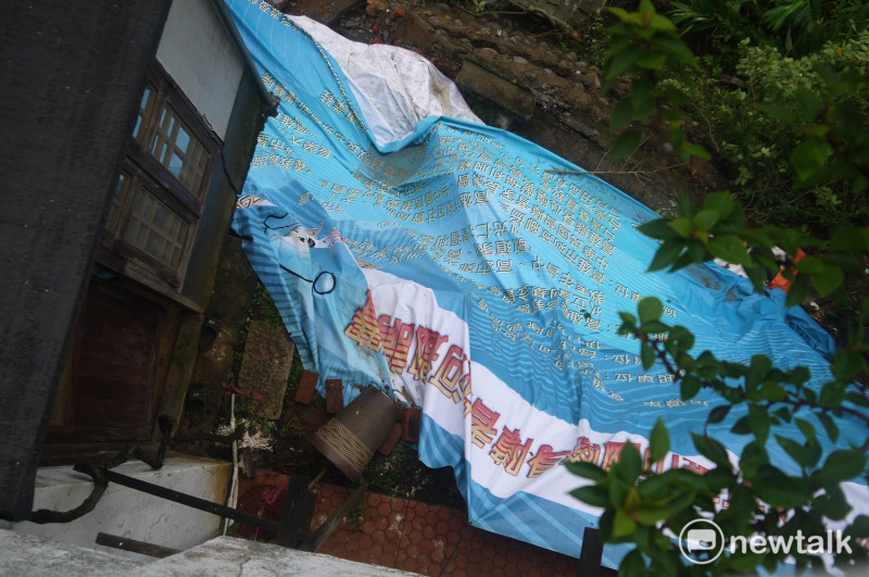 為防止建築地基遭大雨沖刷，居民以帆布覆蓋土地。   圖：鍾孟軒/攝
