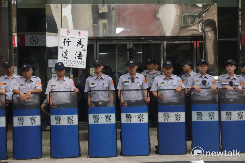 臺灣鐵路產業工會今日前往勞動部前抗議，大批警力戒備，舉牌要求解散。   圖：鍾孟軒/攝