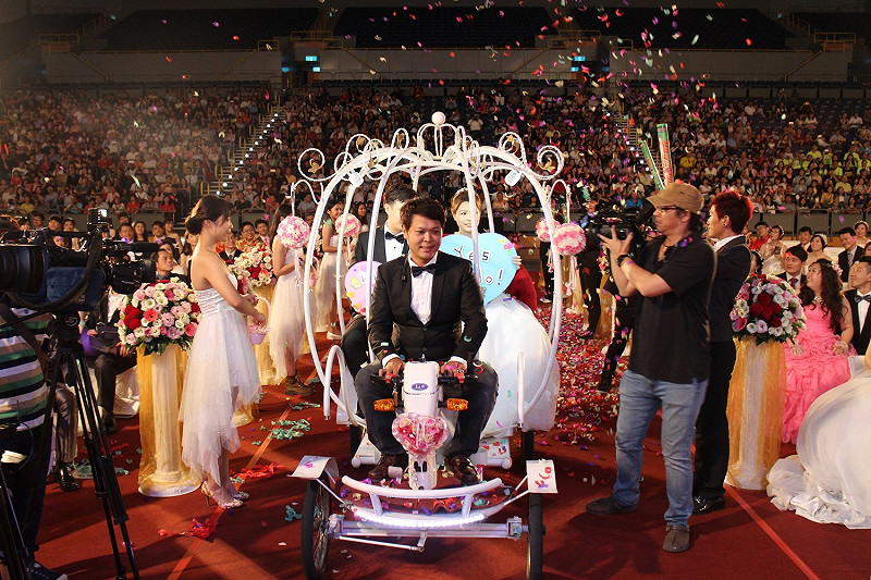新人代表乘坐象徵愛情的南瓜車，由小提琴手及6對伴郎、伴娘引領入場，將浪漫氣氛帶到最高點。    圖 : 高雄市政府/提供