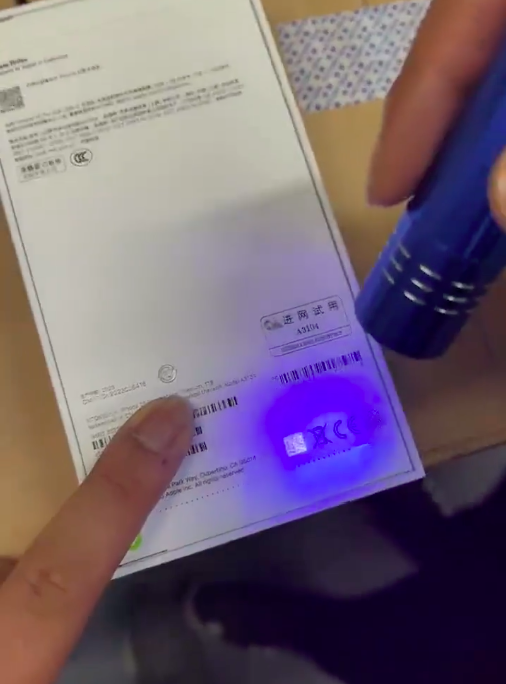 透過紫外線光照射，在右上角藏著 iPhone 15字樣的浮水印以及一組QR碼，在下方認證機構左側也還有一組QR碼   圖：擷取自Majin Bu的X