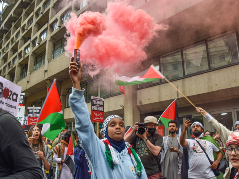 英國首都倫敦國王學院外，一群挺巴勒斯坦民眾點燃信號彈並揮舞旗幟。   圖／達志影像