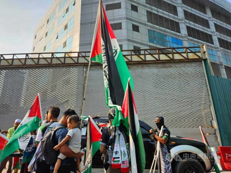 馬來西亞民間社團28日集會力挺巴勒斯坦，參加集會的民眾高舉巴勒斯坦國旗，抗議以色列持續圍困加薩。   圖：中央社提供